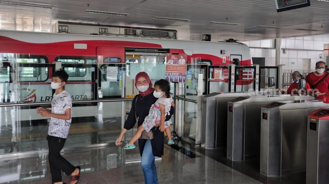 Sejumlah penumpang berjalan meninggalkan gerbong kereta LRT yang berhenti di Stasiun LRT Velodrome, Pulo Gadung, Jakarta, Selasa (1/2/2022). [Suara.com/Angga Budhiyanto]