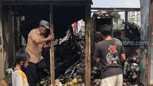 Warga sibuk mengumpulkan barang sisa kebakaran yang hanguskan 100 rumah di Kepa Duri Emas, Kebin Jeruk, Jakarta Barat, Selasa (1/2/2022). [Suara.com/Faqih Fathurrahman]