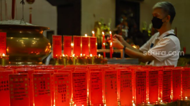 Warga Tionghoa melakukan ibadah malam imlek di Vihara Amurva Bhumi, Jakarta Timur, Senin (31/1/2022). [Suara.com/Alfian Winanto]