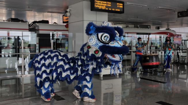 Barongsai beratraksi di Stasiun LRT Velodrome, Pulo Gadung, Jakarta, Selasa (1/2/2022). [Suara.com/Angga Budhiyanto]