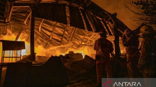 Sejumlah orang berada di sekitar tempat relokasi Pasar Johar yang terbakar, Rabu (2/2/2022) malam. [ANTARA/AJI SETYAWAN]
