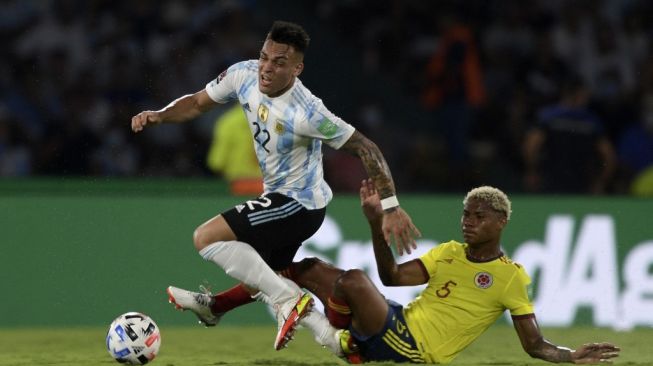 Penyerang timnas Argentina, Lautaro Martinez (kiri) dan pemain Kolombia Wilmar Barrios berebut bola selama pertandingan sepak bola kualifikasi Piala Dunia 2022 zona Amerika Selatan (Conmebol) antara Argentina vs Kolombia di Stadion Mario Kempes di Cordoba, Argentina pada Rabu (2/2/2022) pagi WIB.Juan Mabromata / AFP.