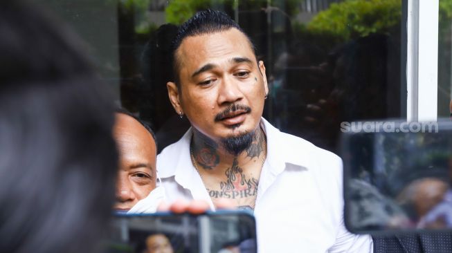 Musisi I Gede Ari Astina atau Jerinx SID menemui awak media ketika hadir untuk menjalani sidang lanjutan kasus pengancaman di Pengadilan Negeri Jakarta Pusat, Rabu (2/2/2022). [Suara.com/Alfian Winanto]