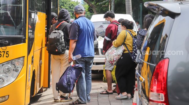 Para pasien Covid-19 saat dievakuasi ke RSDC Wisma Atlet di Puskesmas Kecamatan Tebet, Jakarta Selatan, Kamis (3/2/2022). [Suara.com/Alfian Winanto]