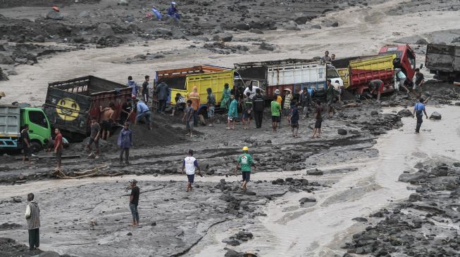 Warga membantu proses evakuasi truk yang terjebak banjir lahar di aliran Sungai Boyong, Sleman, DI Yogyakarta, Kamis (3/2/2022).  ANTARA FOTO/Hendra Nurdiyansyah