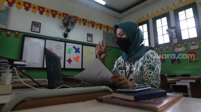 Seorang guru memberikan materi pembelajaran jarak jauh (PJJ) di SDN Gunung 05 Mexico, Jalan Hang Lekir V No 53, Kebayoran Baru, Jakarta, Kamis (3/2/2022). [Suara.com/Angga Budhiyanto]