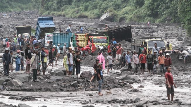 Warga membantu proses evakuasi truk yang terjebak banjir lahar di aliran Sungai Boyong, Sleman, DI Yogyakarta, Kamis (3/2/2022).  ANTARA FOTO/Hendra Nurdiyansyah