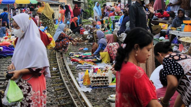 Suasana pedagang berjualan di pinggir rel kereta api di Surabaya, Jawa Timur, Jumat (4/2/2022).  ANTARA FOTO/Patrik Cahyo Lumintu
