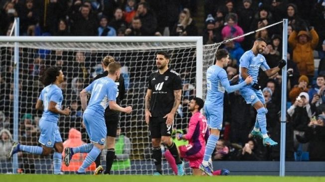 Pemain Manchester City Riyad Mahrez rayakan golnya ke gawang Fulham dalam pertandingan putaran keempat Piala FA di Etihad Stadium, Sabtu (5/2/2022). [AFP]