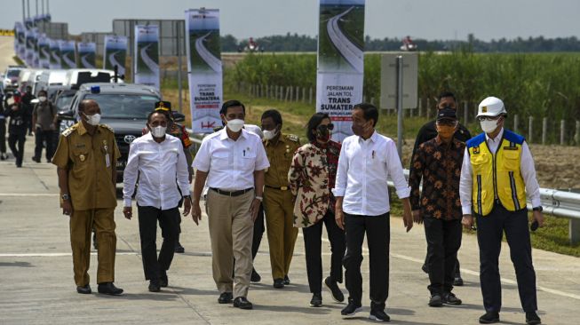 Presiden Joko Widodo (ketiga kanan) didampingi Menteri Koordinator Bidang Kemaritiman dan Investasi Luhut Binsar Pandjaitan (ketiga kiri), Gubernur Sumatera Utara Edy Rahmayadi (kedua kiri), Menteri Keuangan Sri Mulyani Indrawati (keempat kanan) dan pejabat lainnya tiba dilokasi peresmian Jalan Tol Trans Sumatera (JTTS)  seksi I Binjai-Pangkalan Brandan ruas Binjai-Stabat di Langkat, Sumatera Utara, Jumat (4/2/2022). ANTARA FOTO/Fransisco Carolio/Lmo