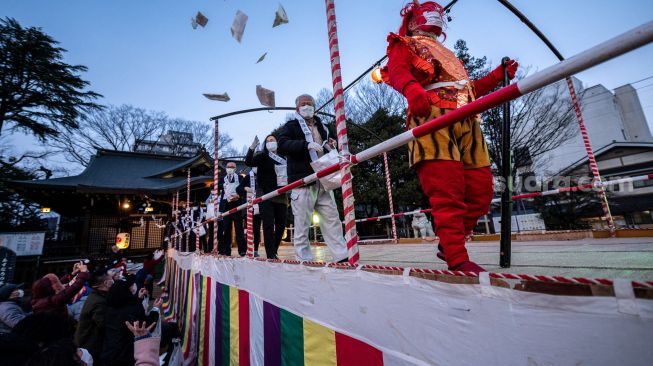 Warga berkumpul untuk tradisi 'Mamemaki' saat perayaan Setsubun di Kuil Fukushima Inari, Jepang, (3/2/2022). [Photo by Philip FONG / AFP]