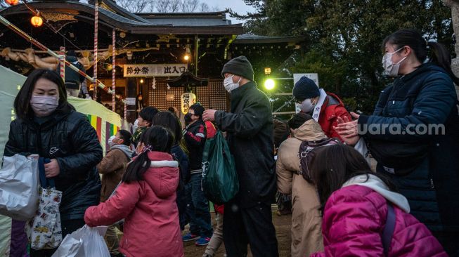 Warga berkumpul untuk tradisi 'Mamemaki' saat perayaan Setsubun di Kuil Fukushima Inari, Jepang, (3/2/2022). [Photo by Philip FONG / AFP]