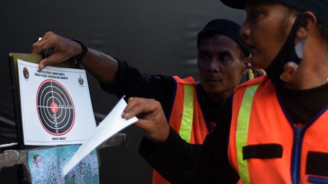 Panitia menyiapkan kertas target untuk lomba ketapel di Kebon Pala, Jakarta Timur, Sabtu (5/2/2022). ANTARA FOTO/Indrianto Eko Suwarso/rwa.