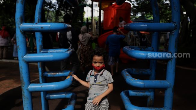 Seorang anak bermain di Taman Lapangan Banteng, Jakarta, Minggu (6/2/2022). [Suara.com/Angga Budhiyanto]