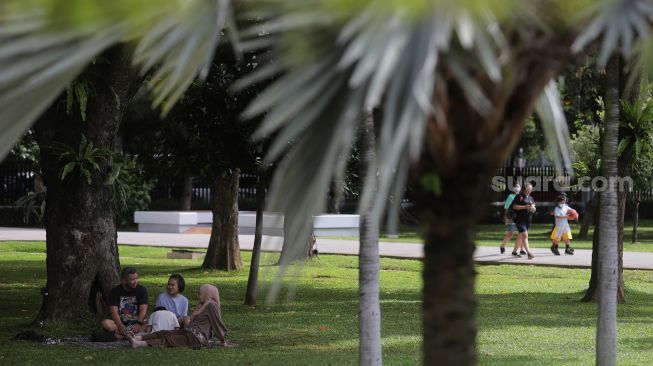 Warga bersantai di Taman Lapangan Banteng, Jakarta, Minggu (6/2/2022). [Suara.com/Angga Budhiyanto]