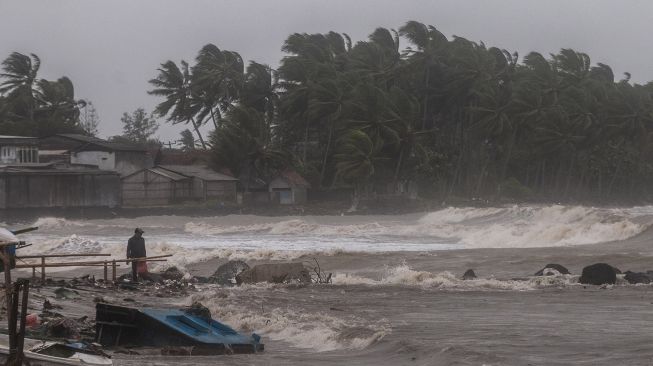 Warga beraktivitas di bibir pantai saat ombak dan angin kencang menerjang kawasan tersebut di Teluk Labuan, Pandeglang, Banten, Minggu (6/2/2022). ANTARA FOTO/Muhammad Bagus Khoirunas