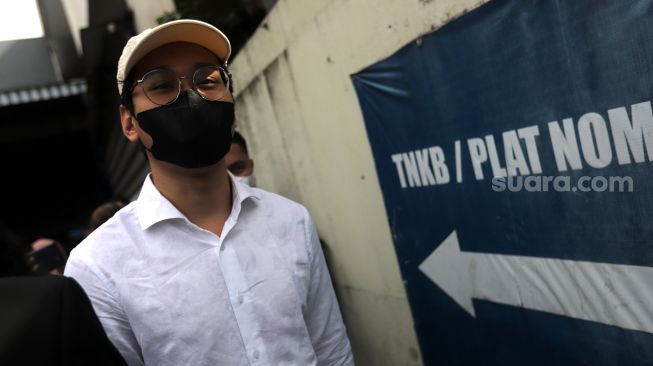 Selebgram sekaligus Youtuber Indra Kesuma atau Indra Kenz berjalan usai memberikan laporan di Gedung SPKT Polda Metro Jaya, Jakarta, Senin (7/2/2022). [Suara.com/Angga Budhiyanto]