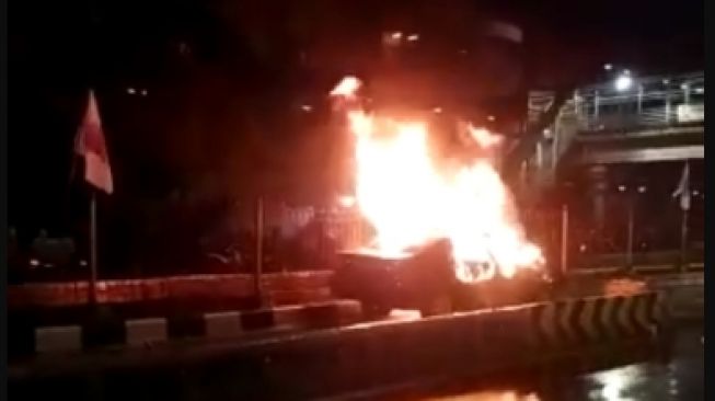 Mobil Toyota Camry terbakar usai menabrak pembatas jalur Transjakarta di Senen. (Foto: Dok. Polres Metro Jakarta Pusat)