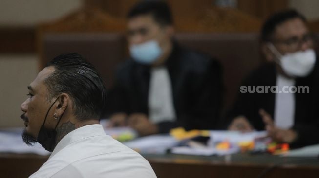 Terdakwa yang juga musisi I Gede Ari Astina atau Jerinx Superman is Dead (SID) menjalani sidang lanjutan kasus pengancaman melalui media elektronik pada Adam Deni dengan agenda mendengarkan keterangan dari saksi ahli di Pengadilan Negeri (PN) Jakarta Pusat, Jakarta, Senin (7/2/2022). [Suara.com/Angga Budhiyanto]