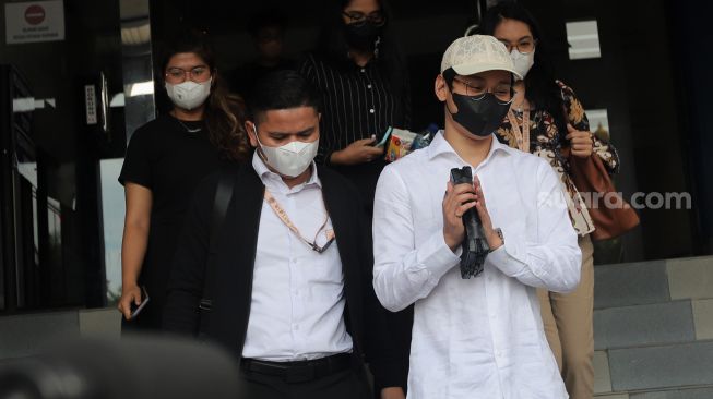 Selebgram sekaligus Youtuber Indra Kesuma atau Indra Kenz (kedua kanan) menyapa awak media usai memberikan laporan di Gedung SPKT Polda Metro Jaya, Jakarta, Senin (7/2/2022). [Suara.com/Angga Budhiyanto]