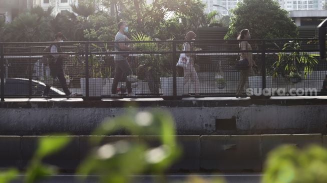 Warga beraktivitas ketika jam pulang kerja di Kawasan Sudirman - Thamrin, Jakarta Pusat, Senin (7/2/2022). [Suara.com/Alfian Winanto]