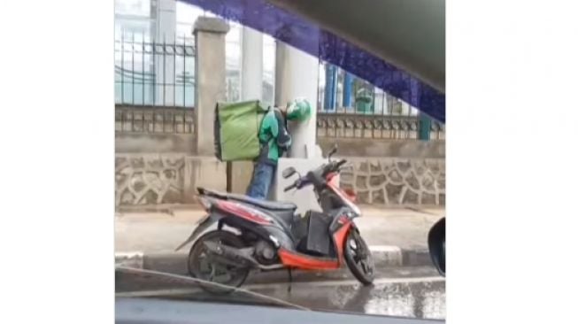 Driver ojol tidur berdiri di tiang penyangga flyover (Instagram/@viralyes)