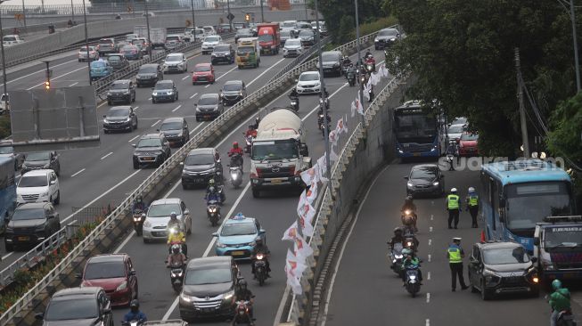 Sejumlah kendaraan melintas di Jalan MT Haryono, Jakarta, Selasa (8/2/2022). [Suara.com/Angga Budhiyanto]