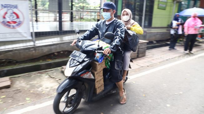 Warga membeli bahan pangan murah dalam kegiatan Program Pangan Bersubsidi di RPTRA Kebon Melati, Jakarta Pusat, Rabu (9/2/2022). [Suara.com/Alfian Winanto]