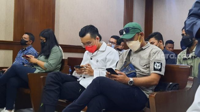 Dokter Tirta (masker merah) di sidang Jerinx, Pengadilan Negeri Jakarta Pusat, Rabu (9/2/2022). [Suara.com/Evi Ariska]