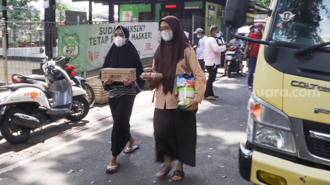 Warga membeli bahan pangan murah dalam kegiatan Program Pangan Bersubsidi di RPTRA Kebon Melati, Jakarta Pusat, Rabu (9/2/2022). [Suara.com/Alfian Winanto]