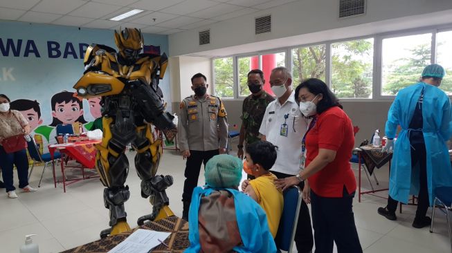 Jalani Vaksinasi di Gunung Putri Bogor, Anak-anak Dihibur Dengan Robot Transformer