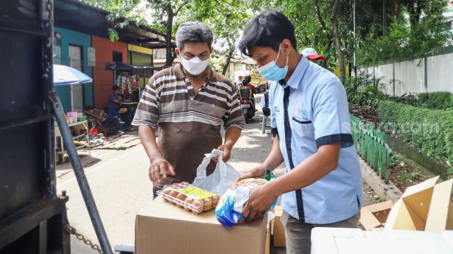 Warga membeli bahan pangan murah dalam kegiatan Program Pangan Bersubsidi di RPTRA Kebon Melati, Jakarta Pusat, Rabu (9/2/2022). [Suara.com/Alfian Winanto]