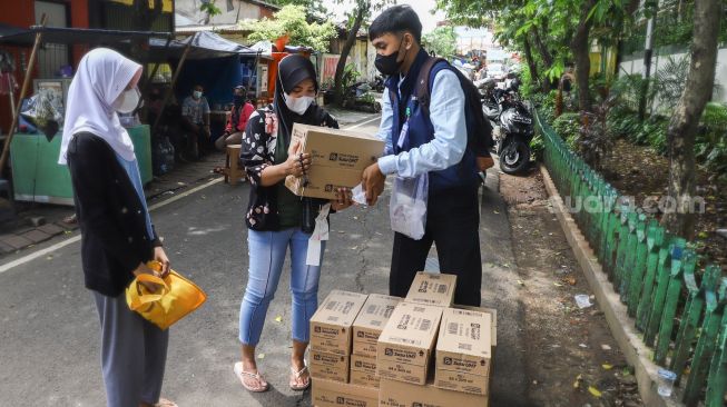 Warga membeli bahan pangan murah dalam kegiatan Program Pangan Bersubsidi di RPTRA Kebon Melati, Jakarta Pusat, Rabu (9/2/2022). [Suara.com/Alfian Winanto]