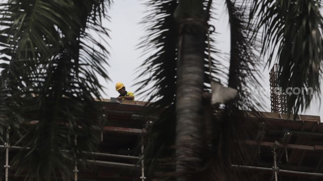 Pekerja menyelesaikan proyek salah satu gedung bertingkat di Jakarta, Kamis (10/2/2022). [Suara.com/Angga Budhiyanto]