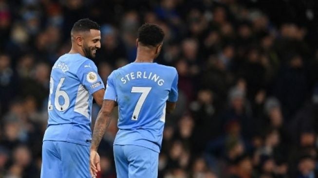 Gelandang Manchester City Riyad Mahrez (kiri) merayakan golnya dengan Raheem Sterling setelah mencetak gol tendangan penalti dalam pertandingan sepak bola Liga Utama Inggris antara Manchester City dan Brentford di Stadion Etihad di Manchester, barat laut Inggris, pada 9 Februari, 2022.Paul ELLIS/AFP