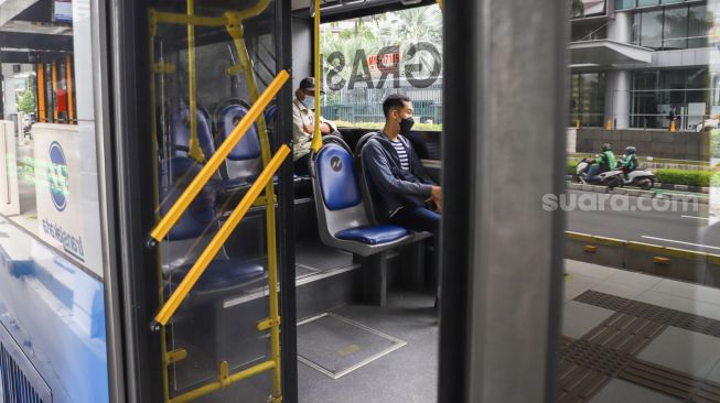 Penumpang menaiki bus Transjakarta di Halte Transjakarta Tosari, Jakarta Pusat Kamis (10/2/2022). [Suara.com/Alfian Winanto]