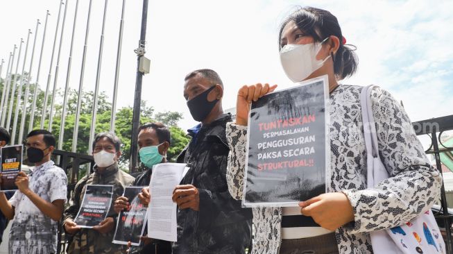 Massa yang tergabung dalam Koalisi Rakyat Menolak Penggusuran (KRMP) berunjuk rasa di depan Balai Kota DKI Jakarta, Jakarta Pusat, Kamis (10/2/2022). [Suara.com/Alfian Winanto]