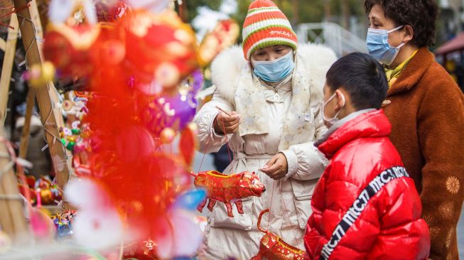 Warga berbelanja lentera menjelang festival lampion di Nanjing, China, Kamis (10/2/2022). [STR/AFP]