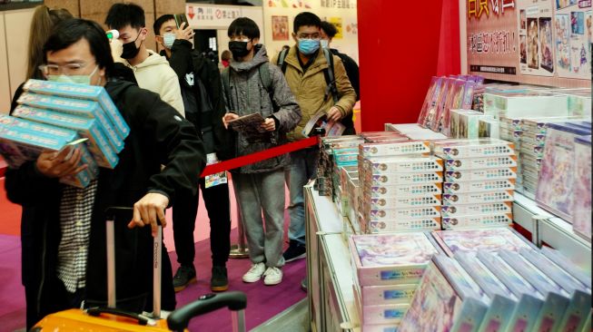 Para pengunjung berbelanja di Festival Komik dan Animasi Internasional ke-10 di Taipei, Taiwan, Kamis (10/2/2022). [Sam Yeh / AFP]