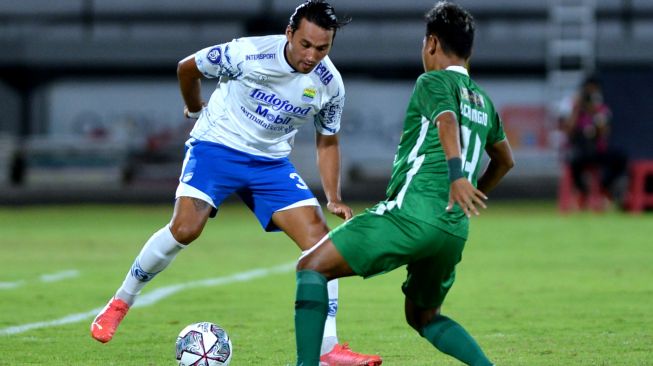 Pesepak bola Persib Bandung Ezra Walian (kiri) berebut bola dengan pesepak bola PSS Sleman Ocvian Chanigio (kanan) saat pertandingan Liga 1 di Stadion Kapten I Wayan Dipta, Gianyar, Bali, Jumat (11/2/2022). [ANTARA FOTO/Fikri Yusuf]