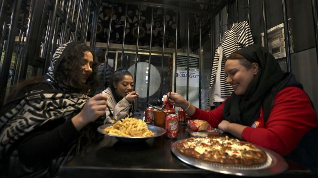 Pengunjung makan malam di restoran "Cell 16' yang berkonsep penjara di Teheran, Iran, Jumat (4/2/2022). [ATTA KENARE / AFP]