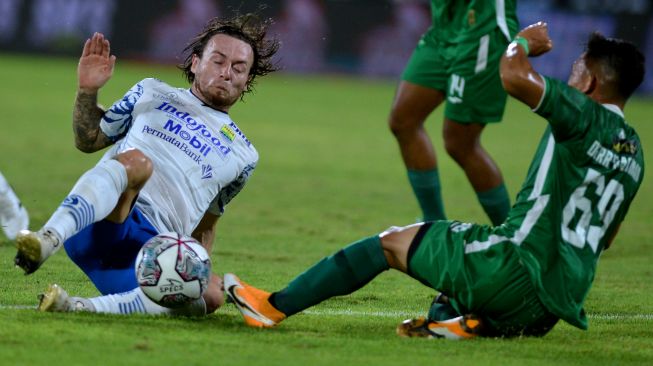 Pesepak bola Persib Bandung Marc Klok (kiri) berebut bola dengan pesepak bola PSS Sleman Derry Rachman Noor (kanan) saat pertandingan Liga 1 di Stadion Kapten I Wayan Dipta, Gianyar, Bali, Jumat (11/2/2022). [ANTARA FOTO/Fikri Yusuf]
