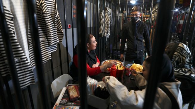 Pelayan menerima pesanan di restoran "Cell 16' yang berkonsep penjara di Teheran, Iran, Jumat (4/2/2022). [ATTA KENARE / AFP]