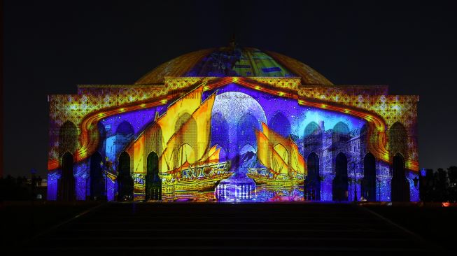 Gedung Univeristas Sharjah menyala dalam tampilan warna-warni saat Festival Cahaya Sharjah ke-11 di Uni Emirat Arab, Kamis (10/2/2022). [Giuseppe CACACE / AFP]
