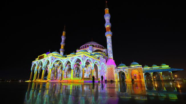 Masjid Sharjah menyala dalam tampilan warna-warni saat Festival Cahaya Sharjah ke-11 di Uni Emirat Arab, Kamis (10/2/2022). [Giuseppe CACACE / AFP]