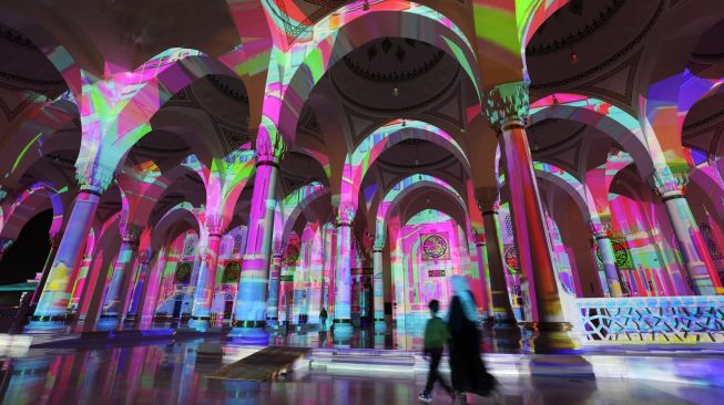 Masjid Sharjah menyala dalam tampilan warna-warni saat Festival Cahaya Sharjah ke-11 di Uni Emirat Arab, Kamis (10/2/2022). [Giuseppe CACACE / AFP]