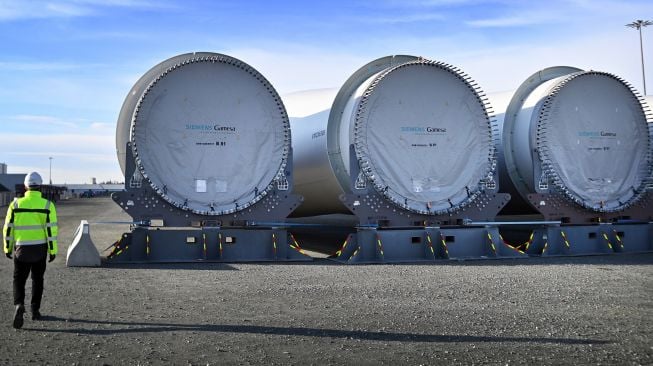 Bilah turbin angin yang disimpan di dermaga dan siap untuk dikirim di pabrik bilah Siemens Gamesa di Hull, Inggris, Jumat (28/1/2022). [Paul ELLIS / AFP]