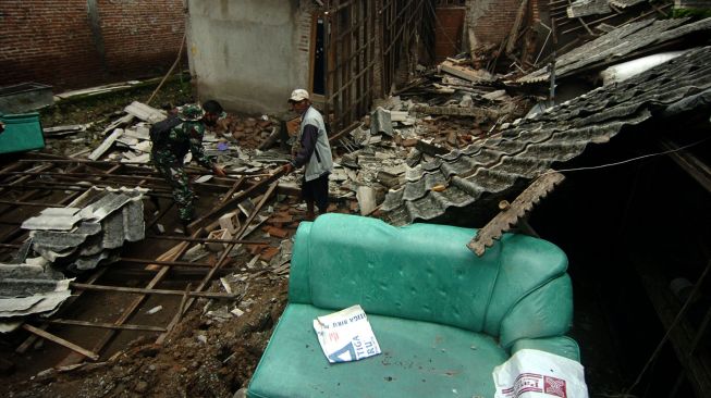 Personel TNI bersama warga membersihkan puing-puing rumah warga yang hancur akibat bencana tanah bergerak di Desa Dermasuci, Kabupaten Tegal, Jawa Tengah, Minggu (13/2/2022). ANTARA FOTO/Oky Lukmansyah