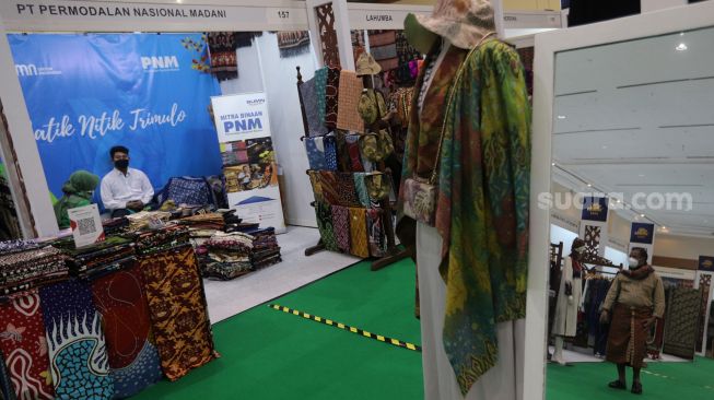 Pengunjung melihat koleksi kain tradisional saat Pameran Adiwastra Nusantara di Jakarta Convention Center (JCC), Jakarta, Minggu (13/2/2022). [Suara.com/Angga Budhiyanto]