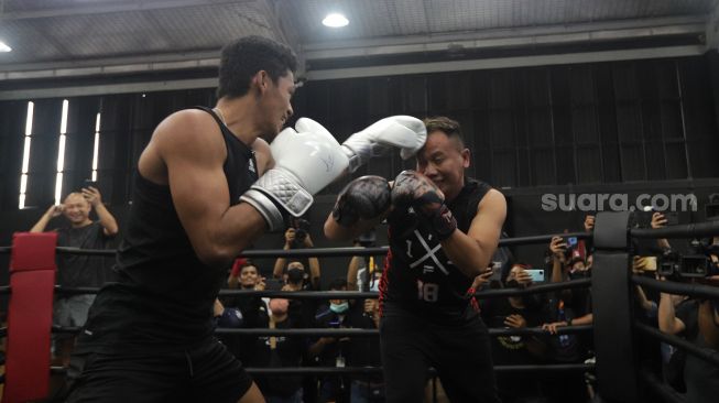 Presenter Vicky Prasetyo beradu tinju (boxing) dengan peraih medali emas PON Papua 2020 Jekson Karmela di United Gym, Cengkareng, Jakarta, Senin (14/2/2022). [Suara.com/Angga Budhiyanto]